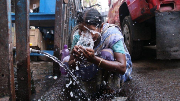 A woman splashes water on her face to get relief from extreme heat in Kolkata.