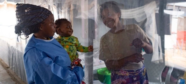 A plastic sheet separates a mother from her son at an Ebola treatment center in North Kivu province, eastern DRC.

