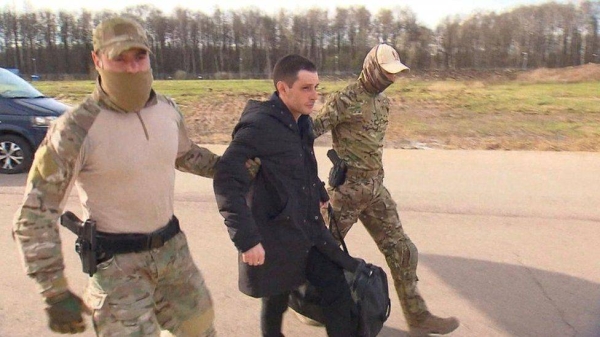 Trevor Reed being escorted to the plane out of Russia on Wednesday.