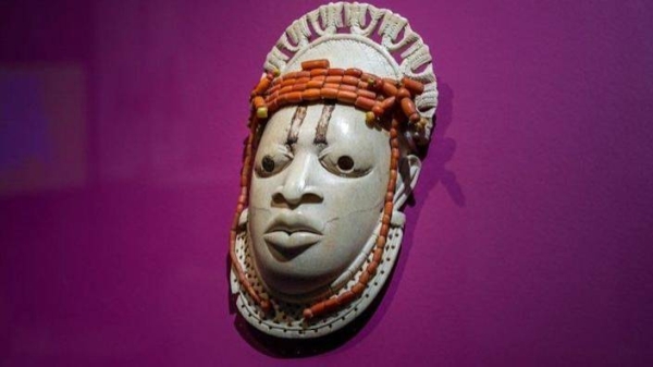 A 19th-century ivory, ceremonial hip mask in honor of Queen Mother Idia and looted by British soldiers from the Kingdom of Benin in 1897 hangs on display in the 