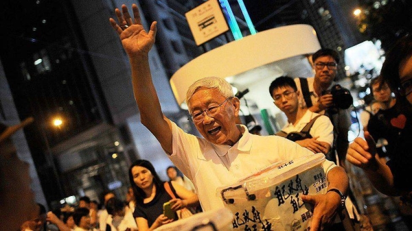 Cardinal Joseph Zen waves to demonstrators during the annual pro-democracy protest in 2014.
