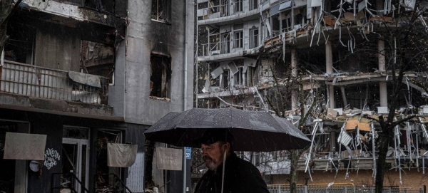 A man walks past destroyed apartment buildings in Kharkiv, Ukraine.

