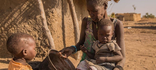 A mother giving sorghum porridge to her children. A growing number of children in South Sudan’s Northern Bahr el Ghazal and Warrap have only one meal per day.
