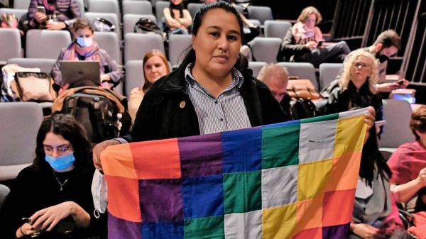 A woman holds an indigenous Wiphala flag during the trial in Buenos Aires, Argentina.