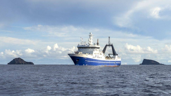 The Tangaroa in front of the two parts of the caldera rim that sit above the ocean surface.