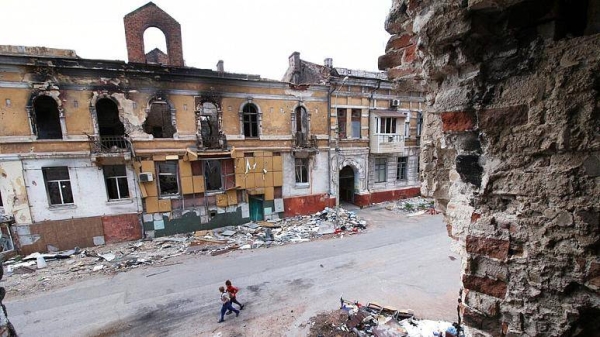 Children walk among buildings destroyed during fighting in Mariupol, in territory under the government of the Donetsk People's Republic, eastern Ukraine.