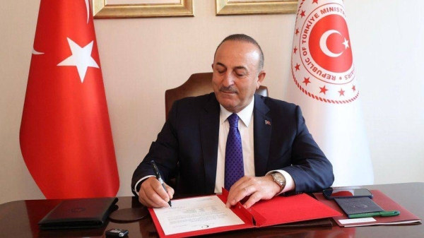 Turkish Foreign Minister Mevlut Cavusoglu signing a document.