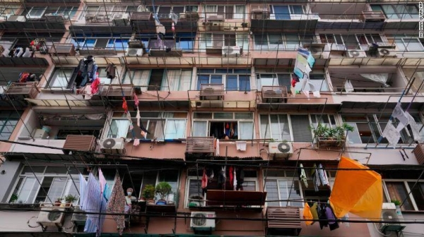 A resident wearing a mask looks out from his home in Shanghai on Thursday.