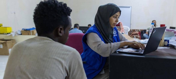 An IOM staff member registers an Ethiopian migrant in Ma’rib, Yemen, prior to travel to Addis Ababa.