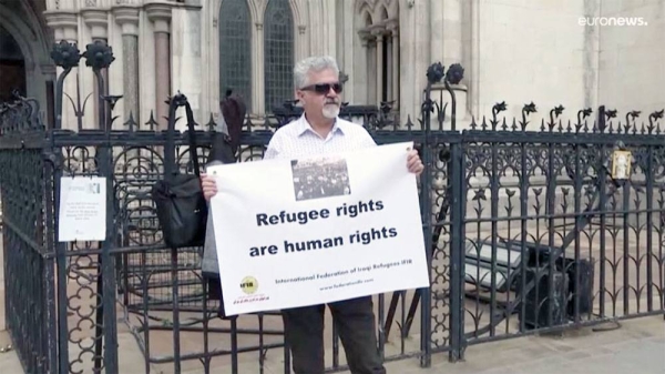 Protestors stand outside The Royal Court of Justice in London. Several NGOs lost a challenge opposing the Home Office's new asylum deal with Rwanda.