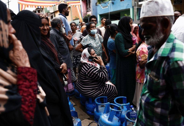 People stand in line to buy domestic gas tanks near a distributor, amid the country's economic crisis, in Colombo