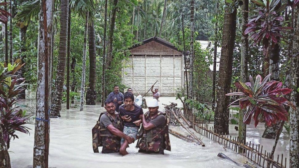 Army personnel wade through flood waters to reach stranded persons. Floods in Assam have killed at least 45 and displaced more than 4.7 million people.