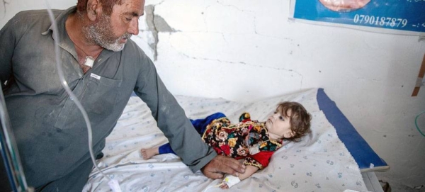 A father and son walk amidst the wreckage of their home, destroyed during the earthquake whick struck Paktika Province, Afghanistan. — courtesy UNICEF/Sayed Bidel