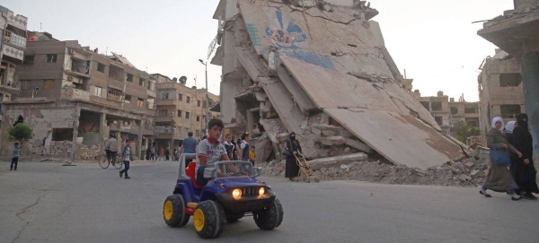 A child rides a toy car in east Ghouta, Syria.