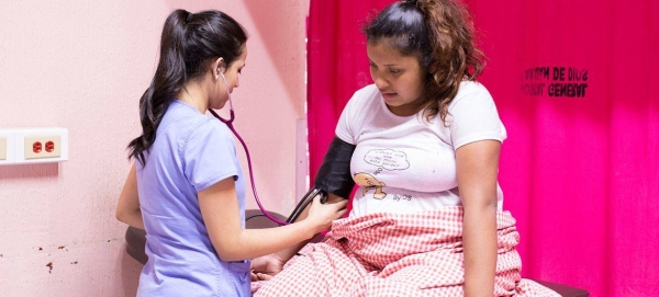 In Guatemala, a nurse monitors a 16-year-old girl who has gone into labor.