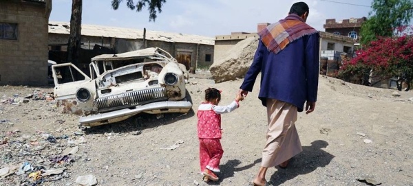 A man walks with his three-year-old daughter in the Harat Al-Masna'a slum in Sanaa, Yemen. — courtesy UNOCHA/Giles Clarke