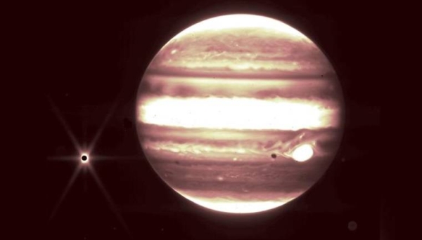 Jupiter, center, and its moon Europa, left, are seen through the Webb telescope's NIRCam instrument.