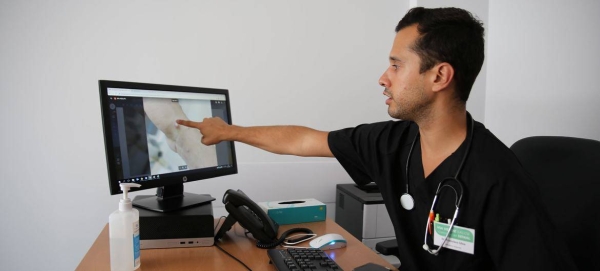 A doctor looks at an image of a monkeypox lesion on his computer screen at a sexual health clinic in Lisbon, Portugal.