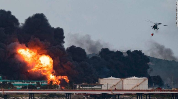 A firefighter helicopter drops water on a massive fire at a fuel depot in Matanzas, Cuba, on August 8.