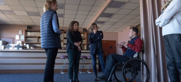 A specialist from the UN Development Fund (UNDP) meets in Ukraine with a person with disabilities and others.