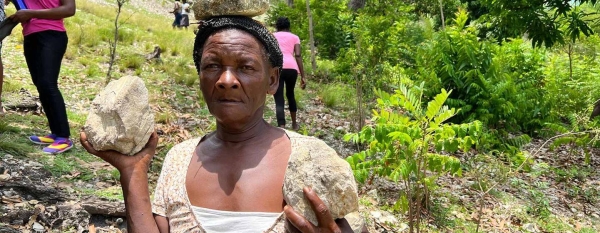 A woman brings stones to build flood-defence barriers.