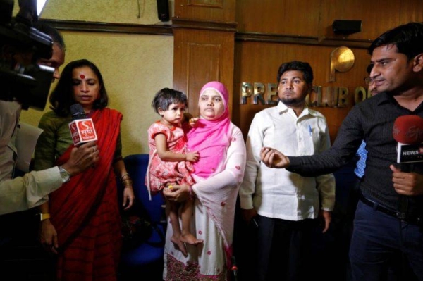 Bilkis Bano holds her two-year-old daughter as her husband Yakub Rasool looks on during a news conference in New Delhi in 2017.