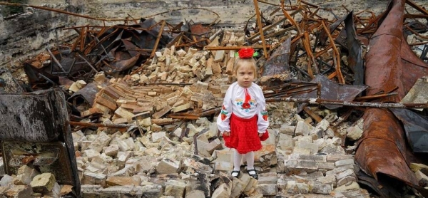 A young girl stands in the rubble of her damaged school in Horenka, in the Kyiv region of Ukraine.