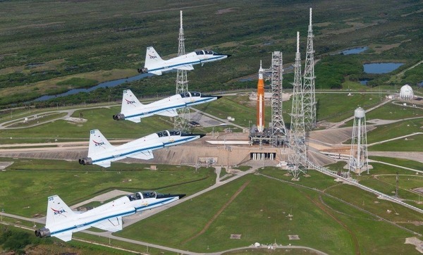 T-38 planes, a fixture of astronaut training at Nasa, fly over the SLS on launch pad 39B at Kennedy.
