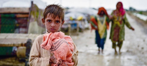 A child holds on to his belongings as families move to safer areas after floods in Balochistan province, Pakistan. — courtesy UNICEF/A. Sami Malik