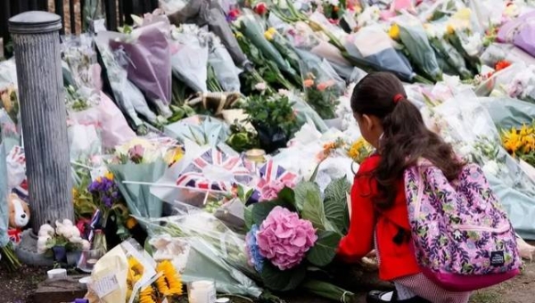 A girl leaves flowers at Windsor Castle on Friday, following the death of Queen Elizabeth II.