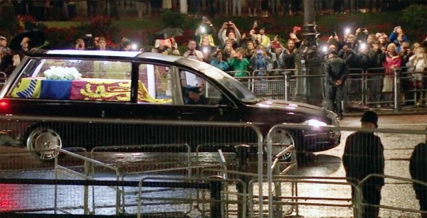People waved as the hearse, with lights inside illuminating the flag-draped coffin, made its way into London after the Queen arrived from her final voyage from Edinburgh to the capital by plane.
