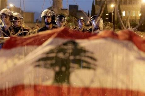Lebanese riot police stand guard in front of the government palace behind a barbed wire barricade decorated with the national flag by anti-government protesters in downtown Beirut, Lebanon, Monday, Oct. 22, 2012. (File)