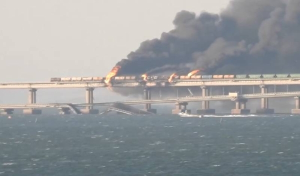 Flame and smoke rise from the Crimean Bridge connecting Russian mainland and the Crimean peninsula over the Kerch Strait.