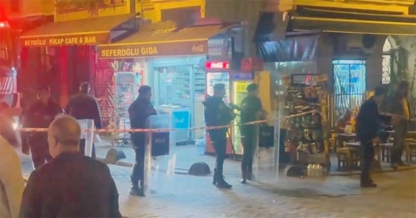 Police officers stand on the street near shops after an explosion on Istanbul’s popular pedestrian Istiklal Avenue, late Sunday.