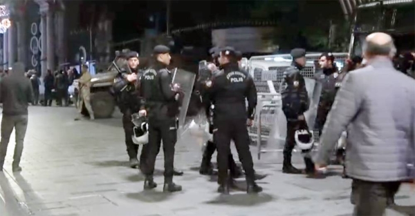 Police officers stand on the street near shops after an explosion on Istanbul’s popular pedestrian Istiklal Avenue, late Sunday.