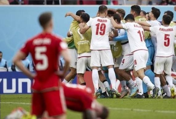 Wales players sink to the turf after Iran's opening goal