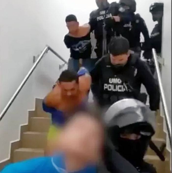 Police leading men out of a hospital after their arrest. — courtesy Policía Ecuador