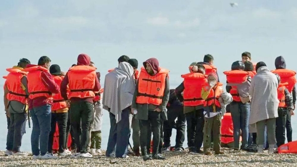A group of people thought to be migrants on the beach in Dungeness, Kent, after being rescued in the Channel by the RNLI following a small boat incident. — courtesy PA Media