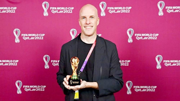 Grant Wahl smiles as he holds a World Cup replica trophy during an award ceremony in Doha, Qatar on Nov. 29, 2022. — courtesy Brendan Moran/FIFA 2022