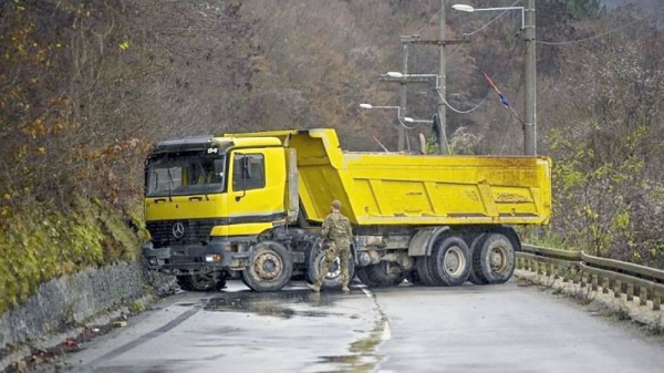 Trucks used as barricade are seen on a road in northern Kosovo, Sunday. — courtesy Armend NimanI/AFP