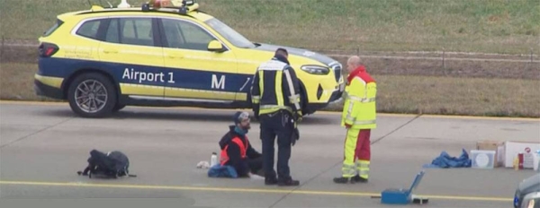 Activists protesting against cheap air travel glued themselves to Munich airport's runway. — courtesy photo YouTube