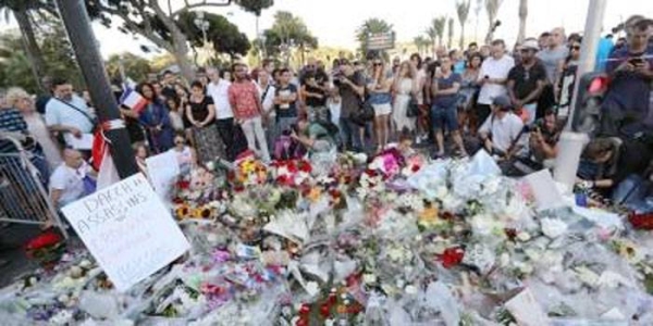 File photo shows flowers piling up at a makeshift memorial in a park on the Nice's promenade following the attack. — courtesy photo