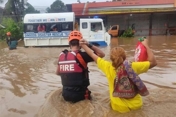 Fire rescue workers help residents evacuate on Christmas day in Gingoog city, Misamis Oriental province, Philippines.