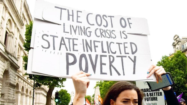 File photo of a protestor holding a placard denouncing the rising cost of living in UK.