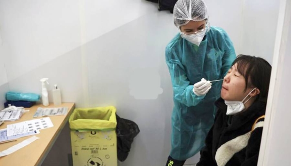 A passenger arriving from China is tested for COVID-19 at the Roissy Charles de Gaulle airport, Paris.