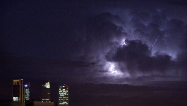 An electrical storm lights up the night sky behind the business district in Madrid