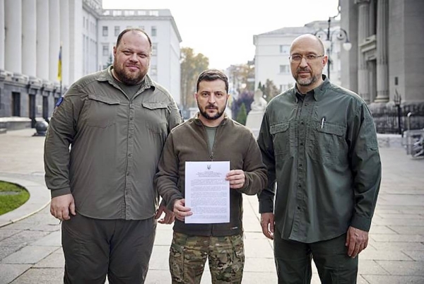 
Ukrainian President Volodymyr Zelensky (center) holds an application for ‘‘accelerated accession to NATO’’ in Kyiv, Ukraine, September 2022. — courtesy Ukrainian Presidential Press Office