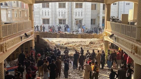 Security officials inspect the site of a mosque blast inside the police headquarters in Peshawar on January 30