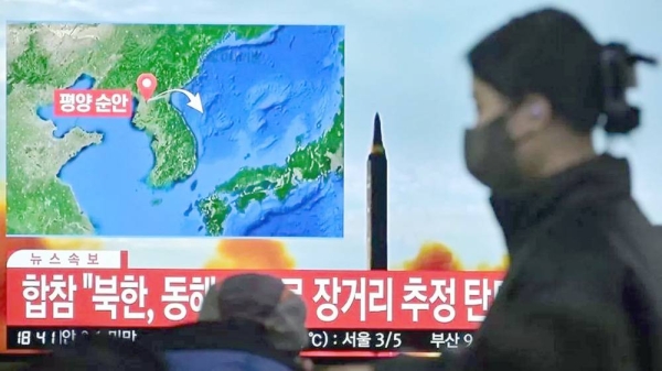 A woman walks past a television showing a news broadcast with file footage of a North Korean missile test, at a railway station in Seoul on Saturday. — courtesy Getty Images