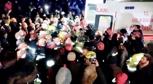Rescue team and people swarm toward the ambulance in which the 17-year-old girl was rescued on Thursday morning.
